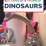 Pin: Christmas dinosaurs! How to make your own dinosaur Advent wreath. With image of a brachiosaurus with a ornament around its neck and tree on its back next to candles