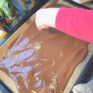 Adding the crushed wheat biscuits/sand to make chocolate dinosaur bark