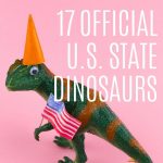 17 official U.S. State dinosaurs: pin with an image of a dinosaur holding a US flag and wearing an orange party hat, metallic stars at its feet